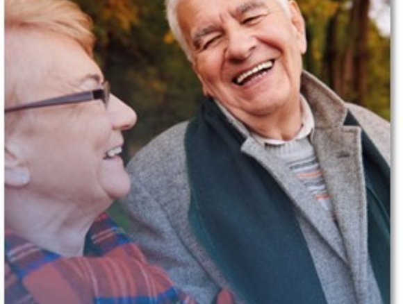 Bejaarde man en vrouw kijken elkaar lachend aan